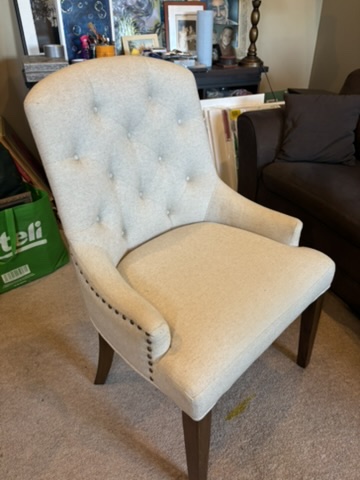 Silla tapizada beige con botones tufted y tachuelas